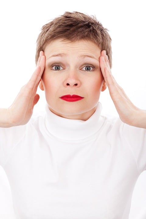  lady wearing red lipstick holding her hands to the sides of her head, stressed.